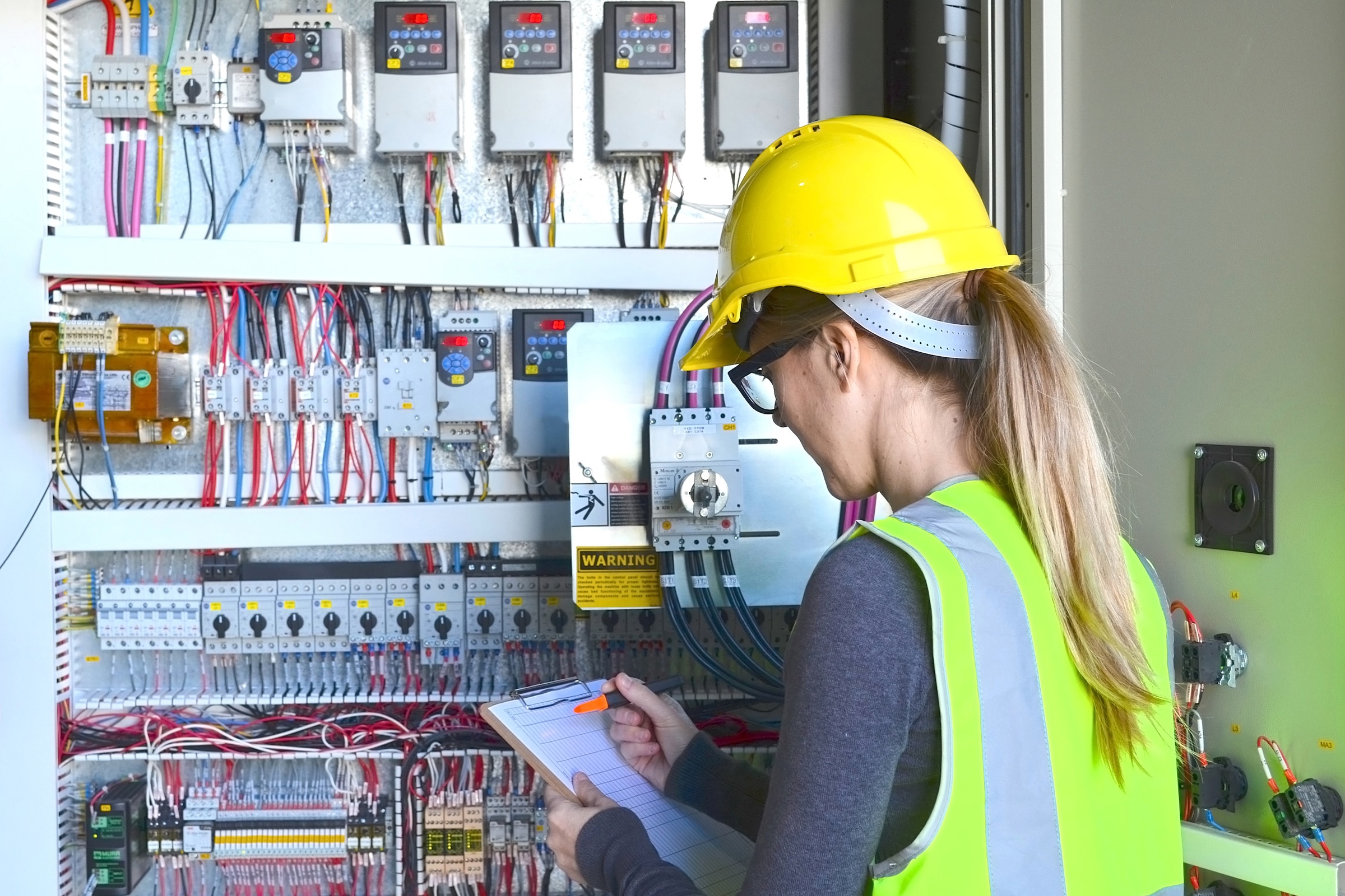 woman in hard hat taking notes