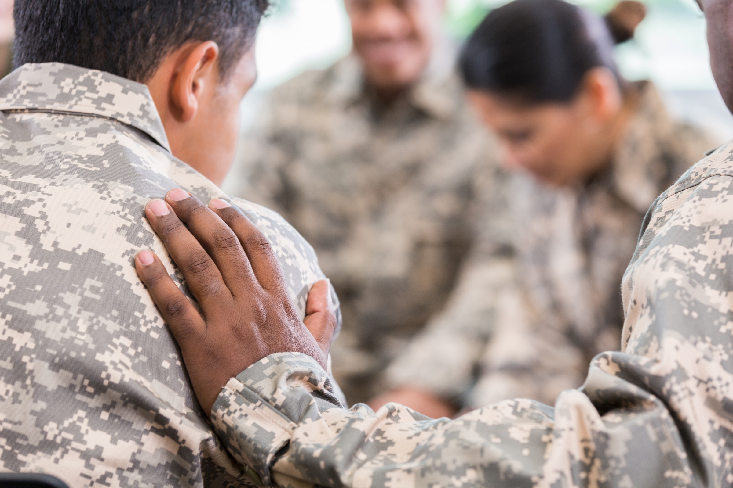 military member placing hand on other soldiers shoulder